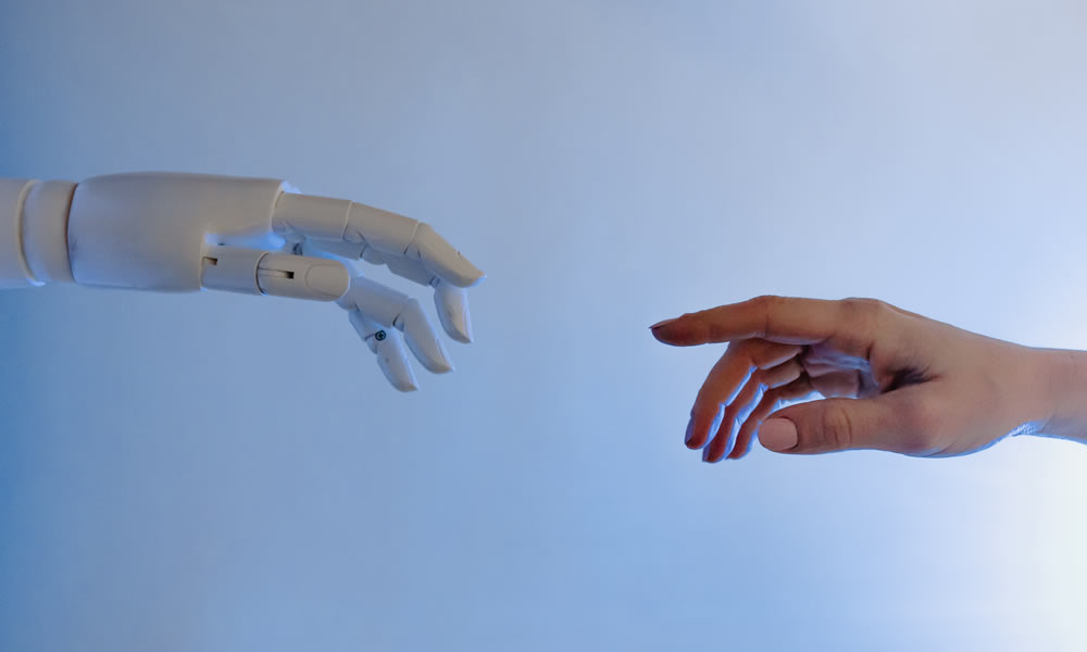 Two hands meeting, one human and the other a robot